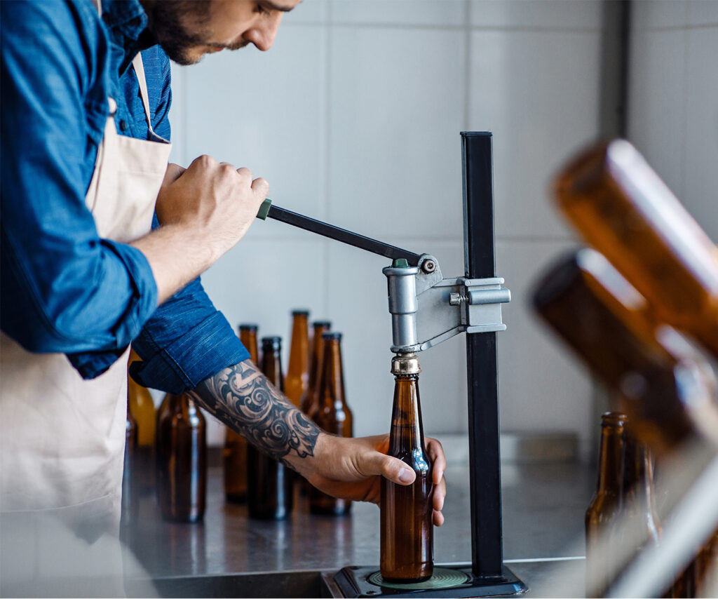 A man pouring craft beer into a bottle