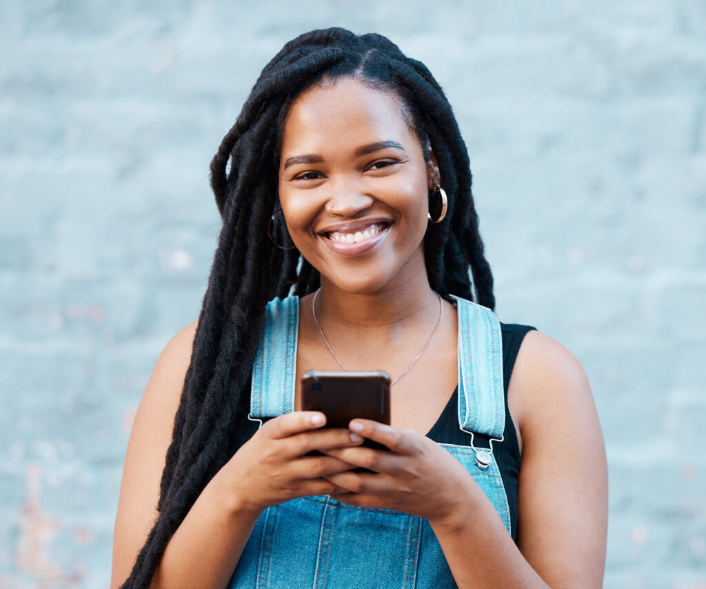Young woman using her phone and smiling