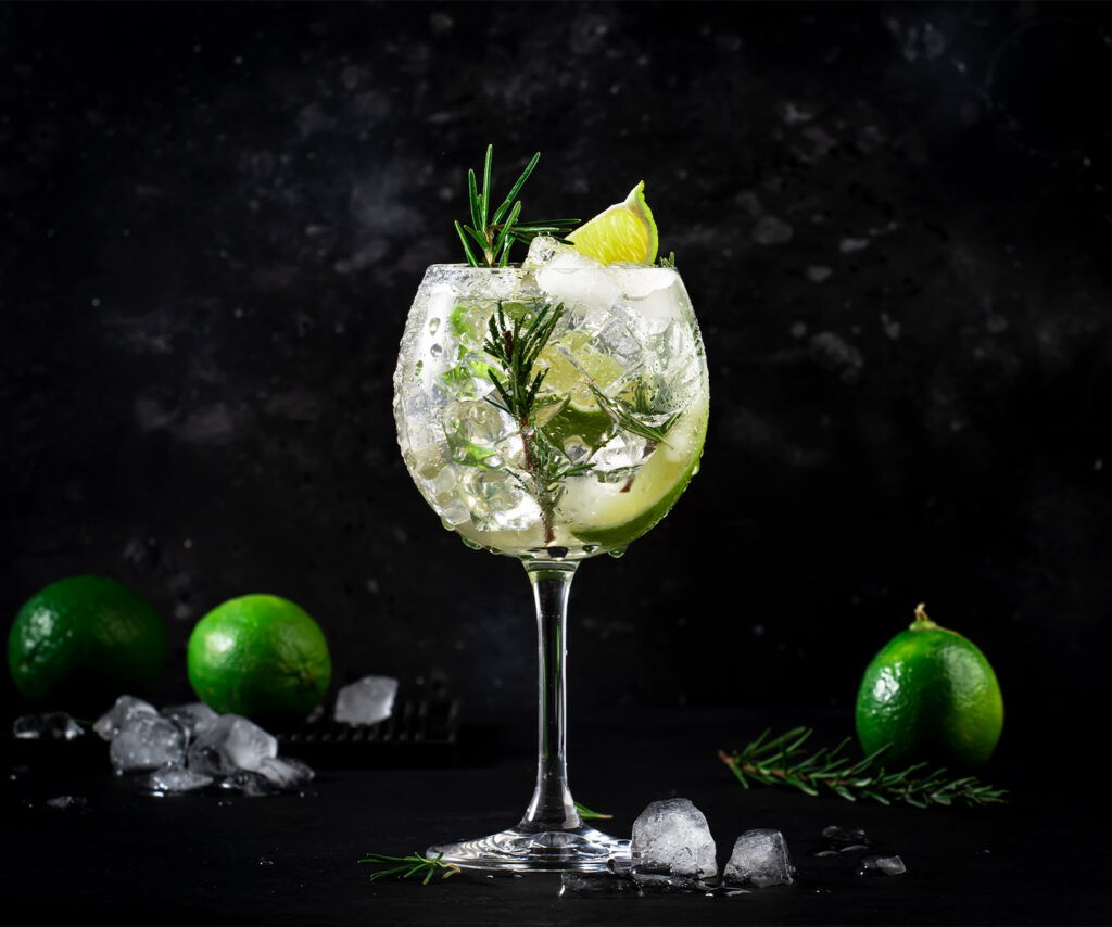 A glass of gin and tonic garnished with lime