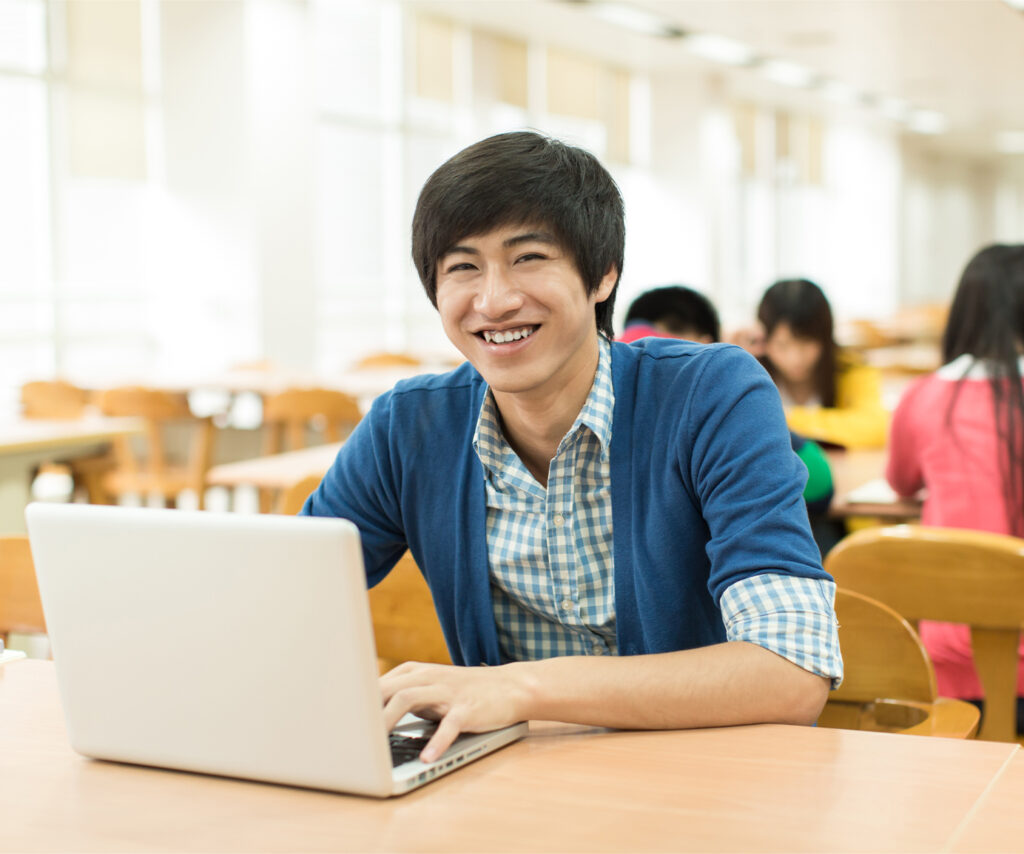 Young man on laptop smiling